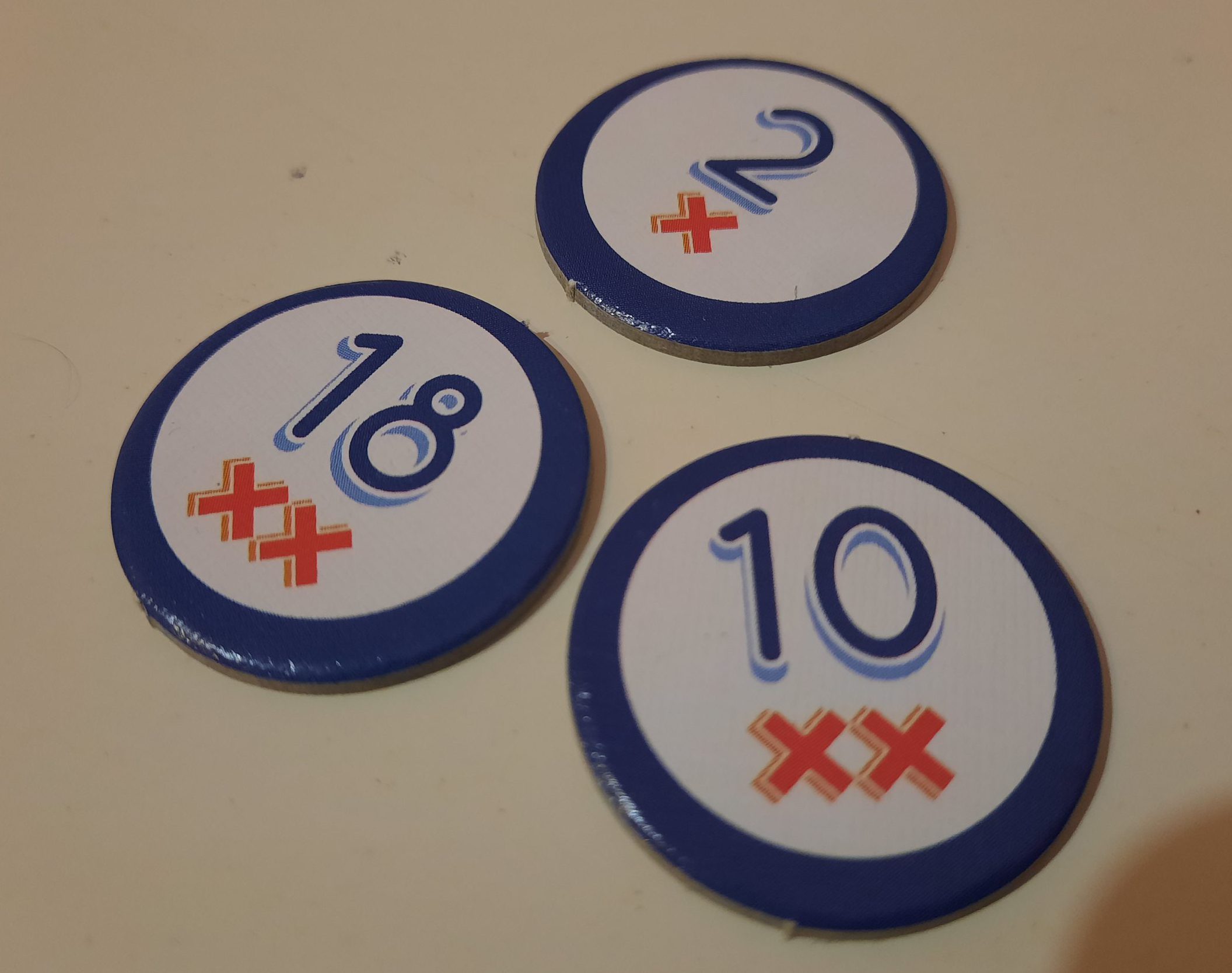 Drei Nummernplättchen mit verschiedener Anzahl von Kreuzen liegen auf dem Tisch.