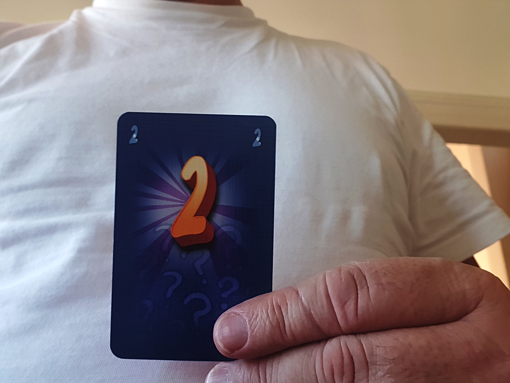 Karte mit der Zahl 2 vor dem Bauch gehalten