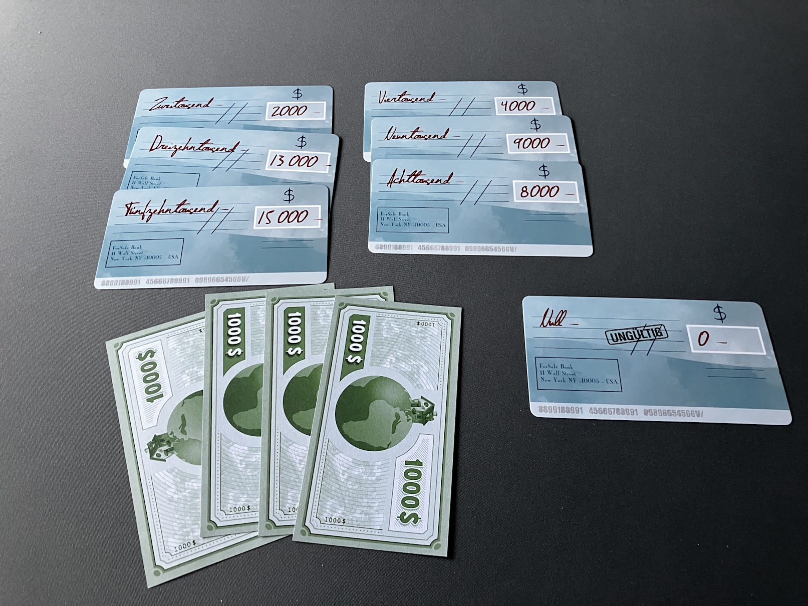 Übrige Geldscheine und Schecks zahlen am Ende Punkte - im Bild liegen 4 Scheine und Schecks im Wert von 51.000