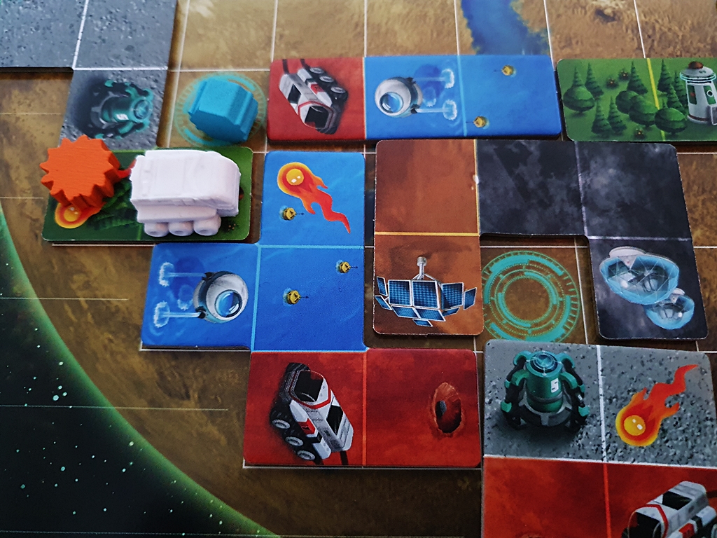 Spielsituation. Ein Teil des Planeten ist mit Plättchen belegt