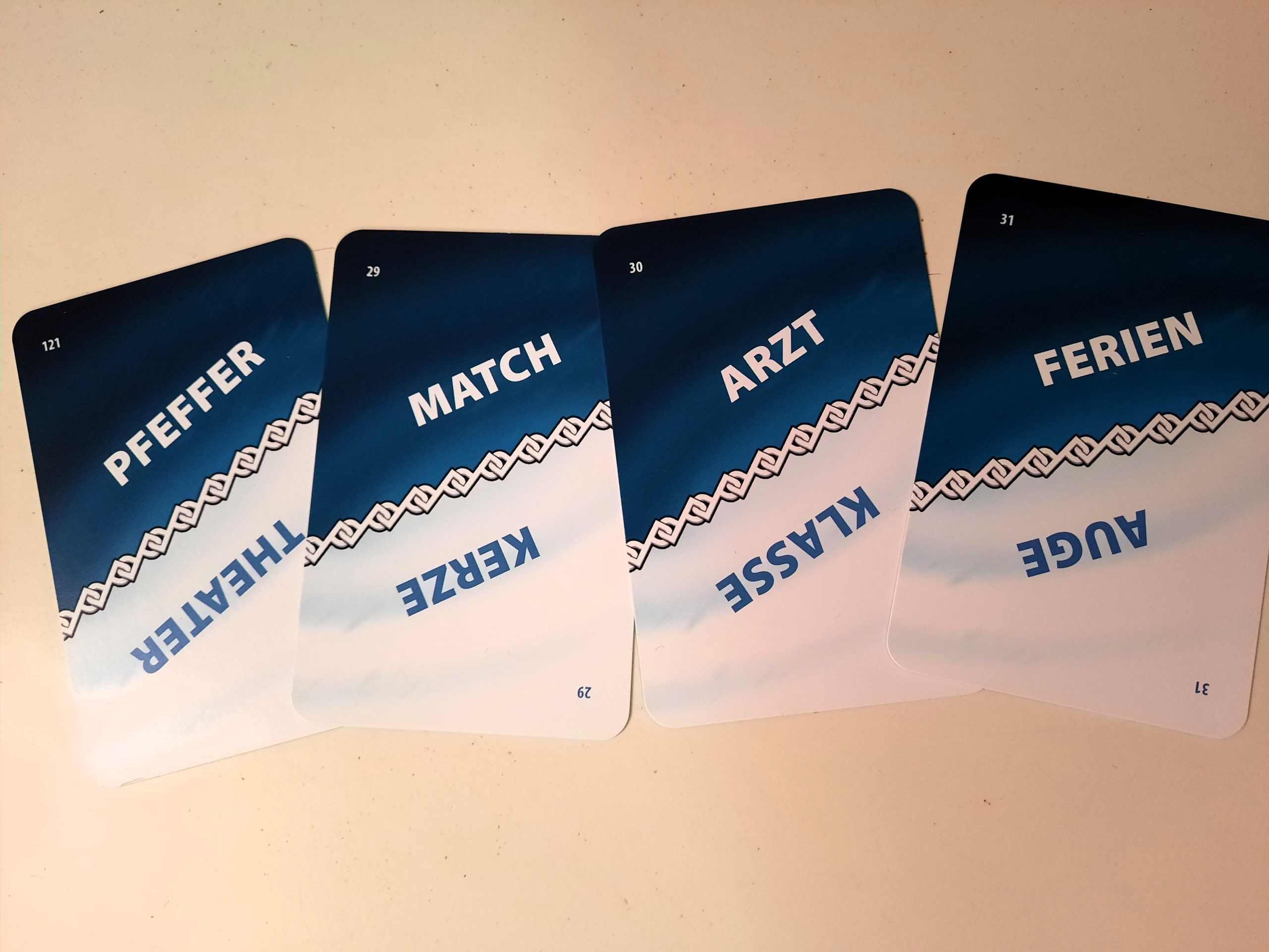Vier Karten mit jeweils zwei Begriffen liegen auf dem Tisch.