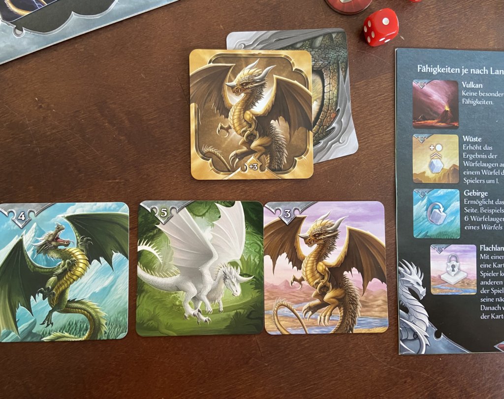 verschiedene Drachenkarten und eine Seite der Anleitung