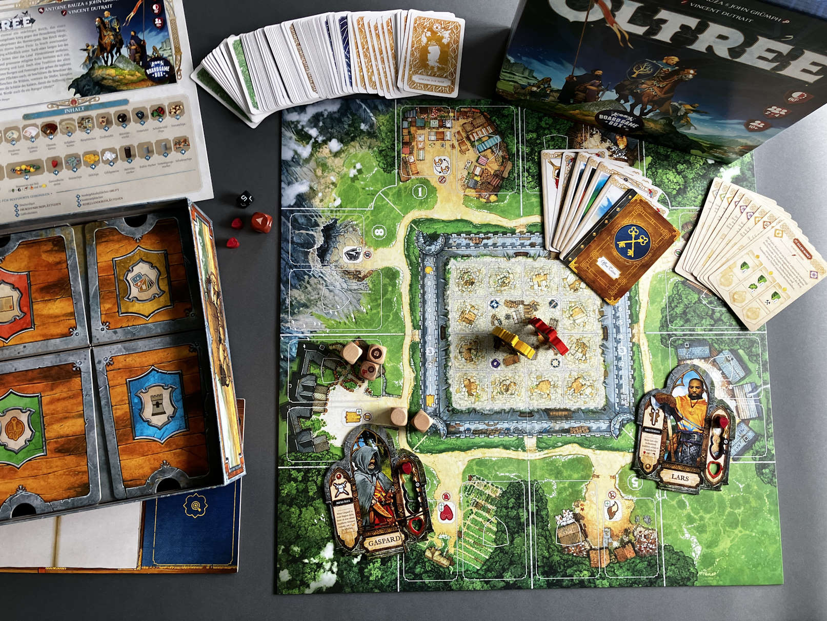 Viel Spielmaterial in Form von Karten liegt ausgebreitet auf dem Tisch