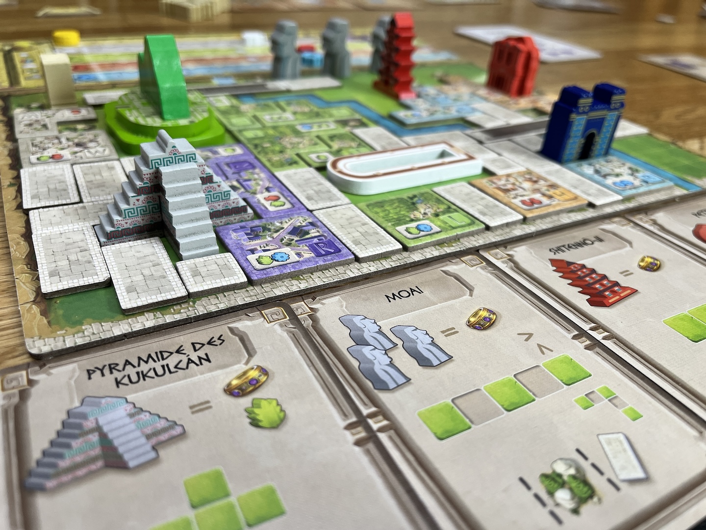 Spielszene aus dem vorangeschrittenen Spiel mit reichlich Material auf dem Spieltableau