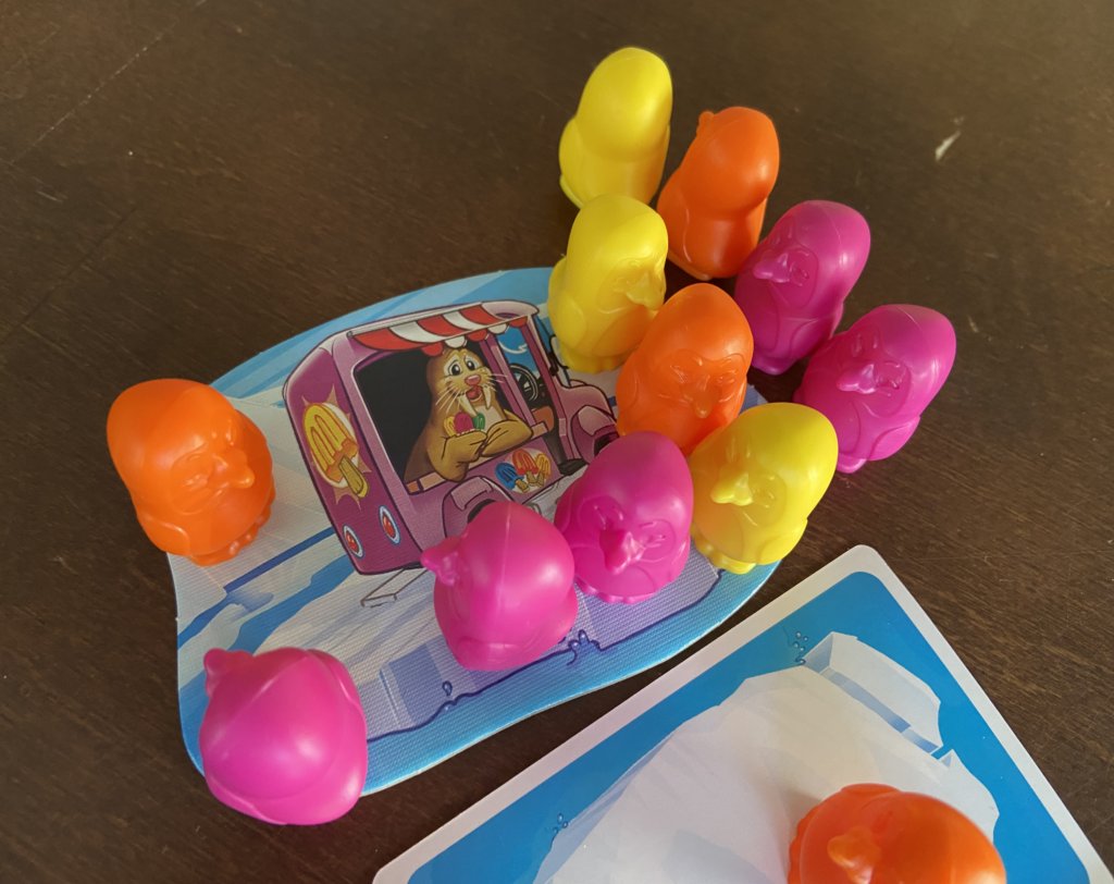 Viele Pinguinfiguren stehen auf dem Zielfeld, der Eisdiele.