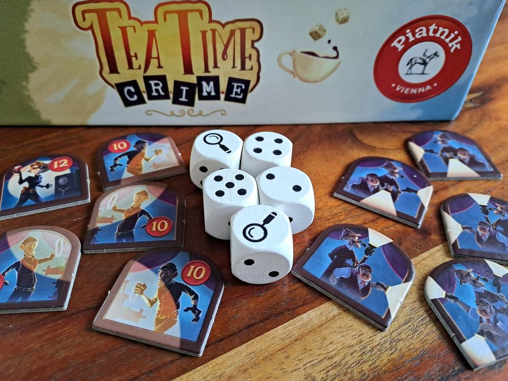 Gezeigt werden die Einbrecherplättchen, die Detektivplättchen und die Würfel.