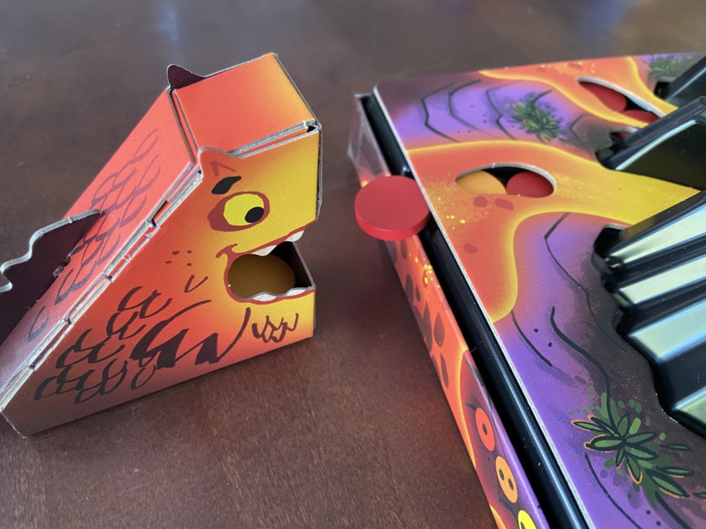 Eine Drachenfigur steht vor dem herausfallenden Lavachip