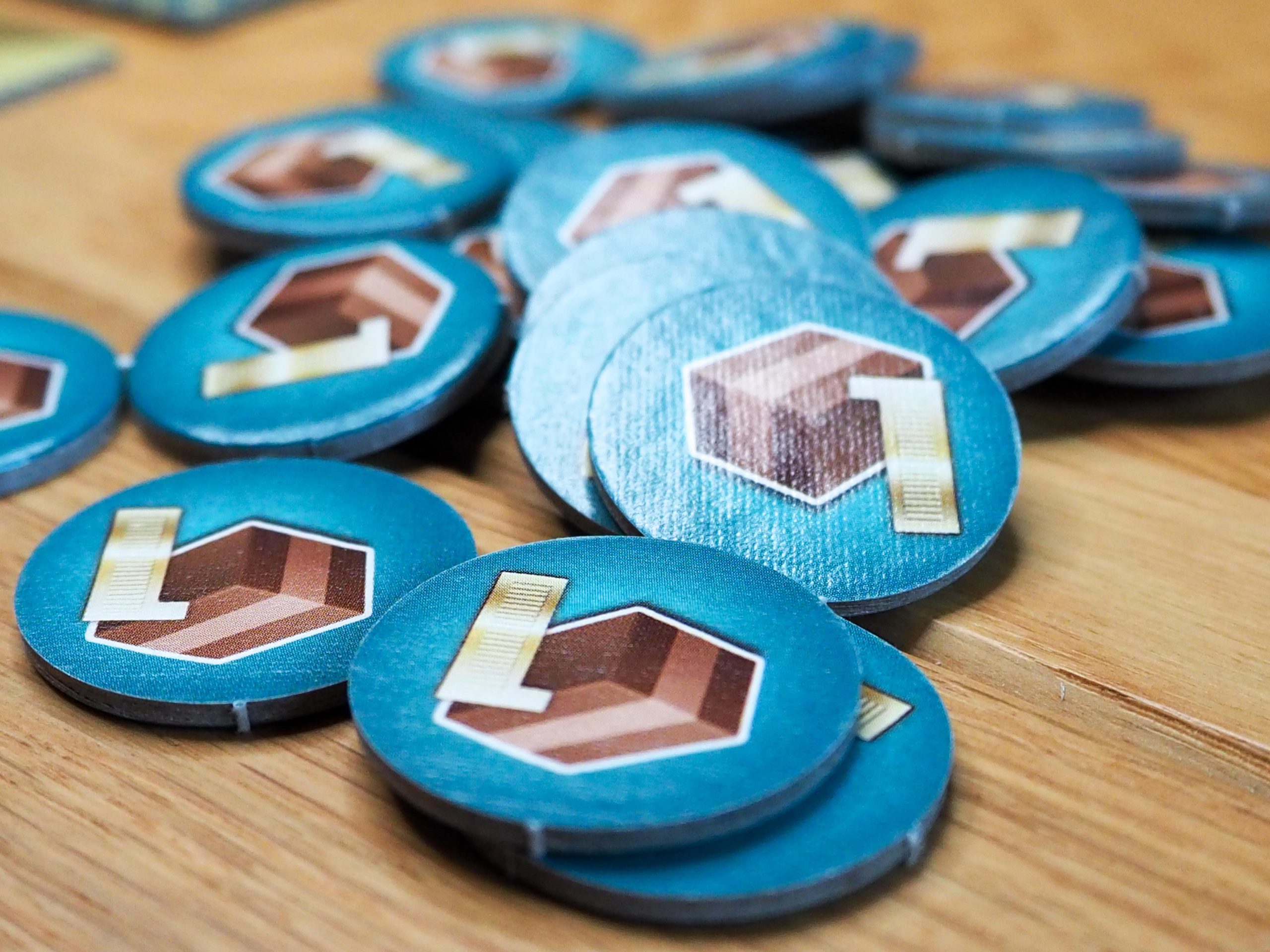 Ein Haufen mit blauen, runden Spielsteinen mit einem Nougatwürfel darauf.