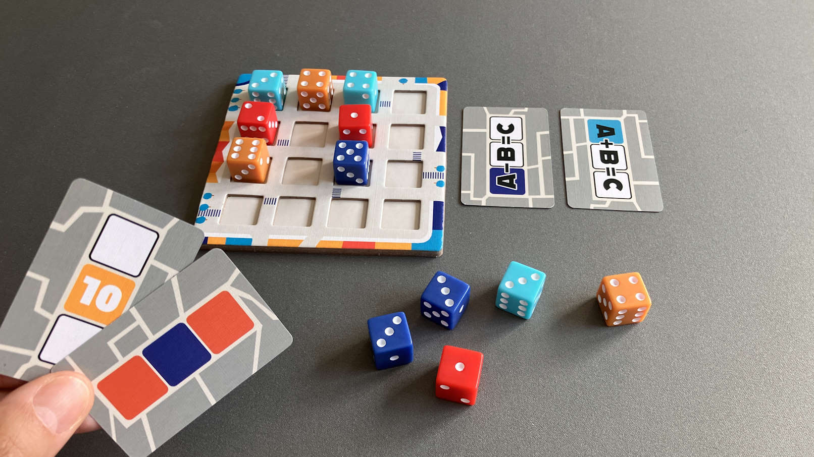 Zwei erfüllte Wertungskarten liegen demonstrativ neben dem Spielplan