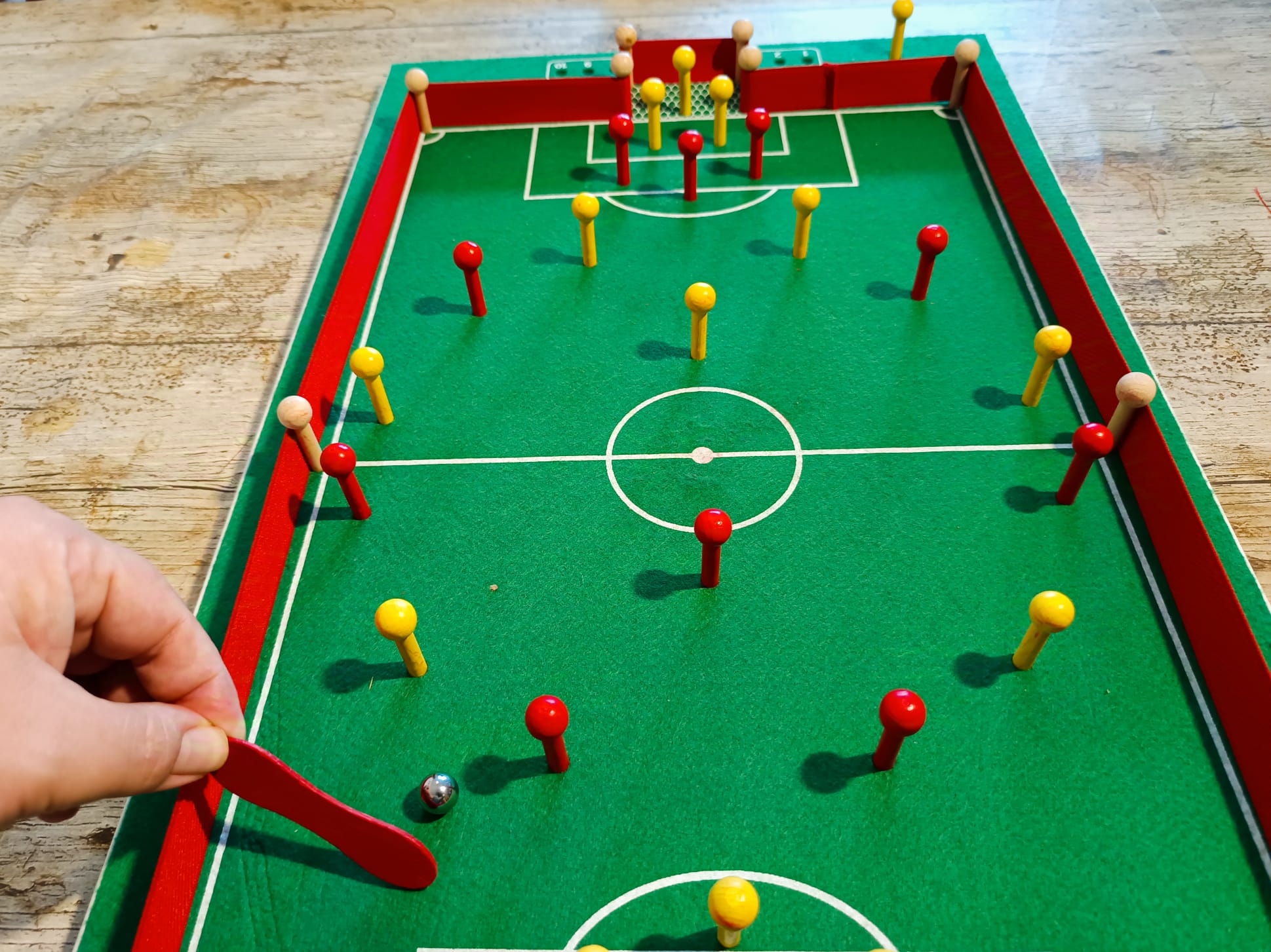 Mit einem Holzstab wird die Kugel angestoßen.