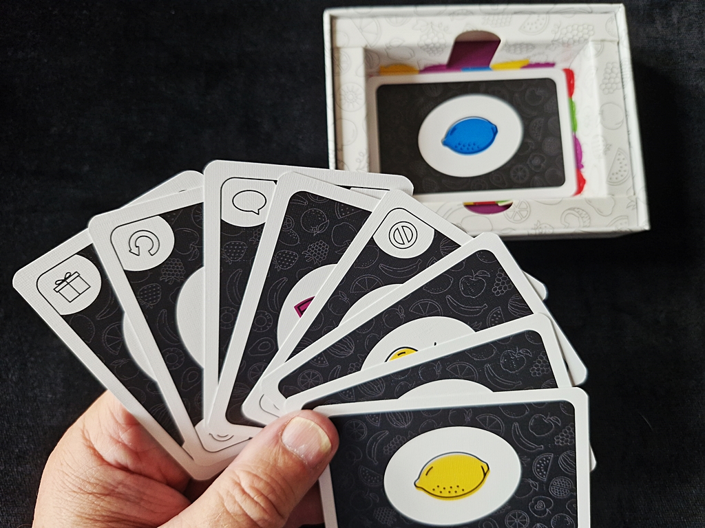 Kartenhand zu Beginn einer Partie. Der Kartonboden dient dem Ausspielen der Karten