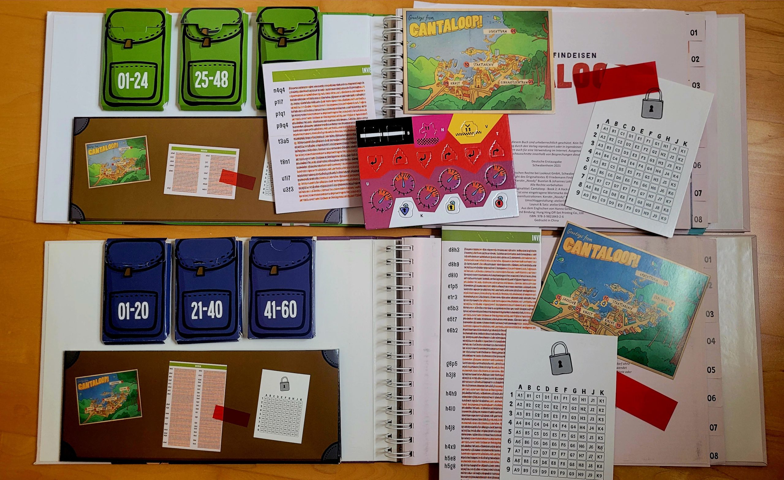 Die beiden geöffneten Bücher zeigen das Spielmaterial