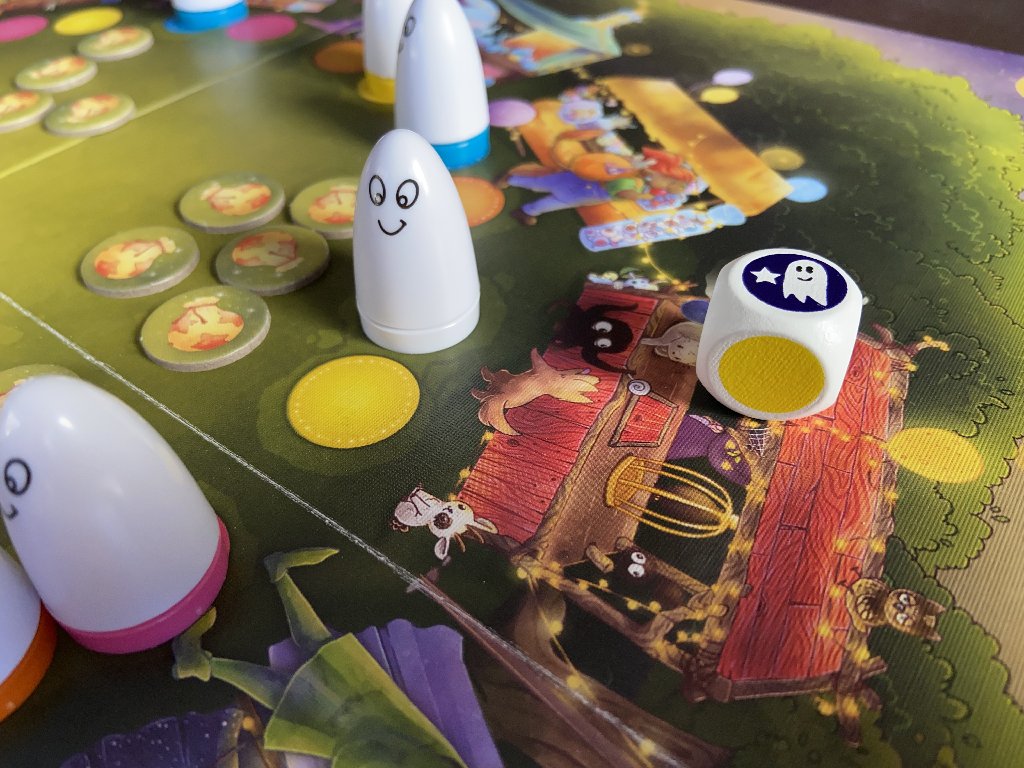 Gespensterfiguren auf dem Spielplan und daneben ein Würfel mit einem Geistsymbol