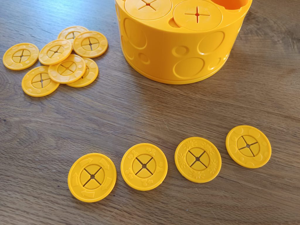 Auf dem Bild sind die vier unterschiedliche Käseringe zu sehen, die das Spiel beinhaltet.