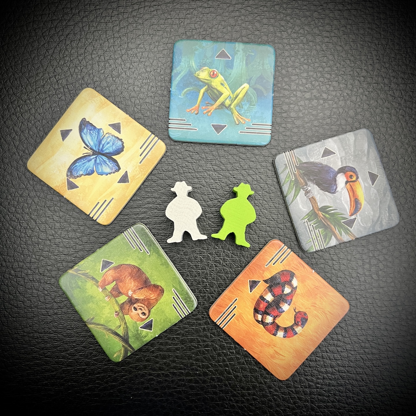 Zu sehen sind 5 Tierplättchen und zwei Spielfiguren.