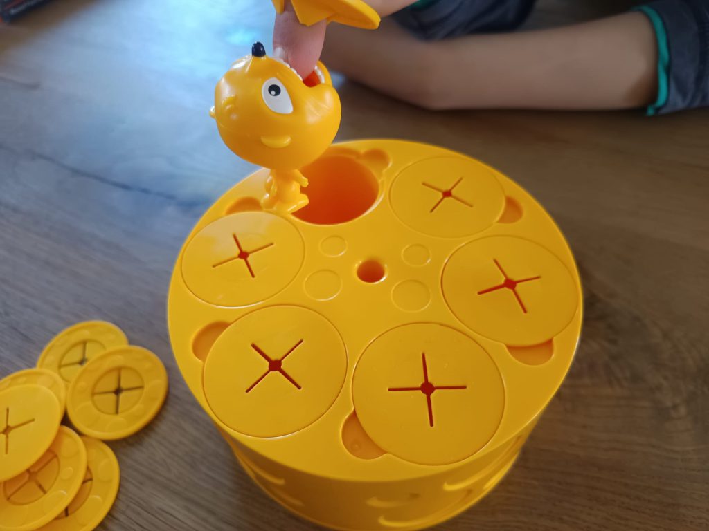 Auf dem Bild beißt sich Cheesy, die Maus, in den Finger rein.