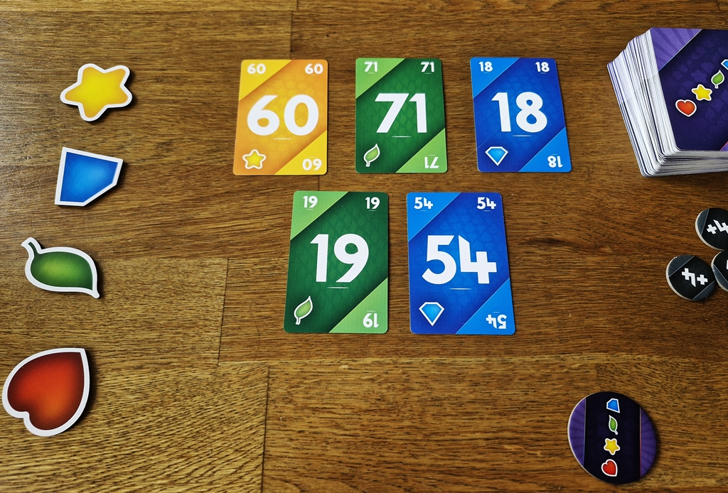 Die Startauslage von fünf Karten bei drei Mitspielenden