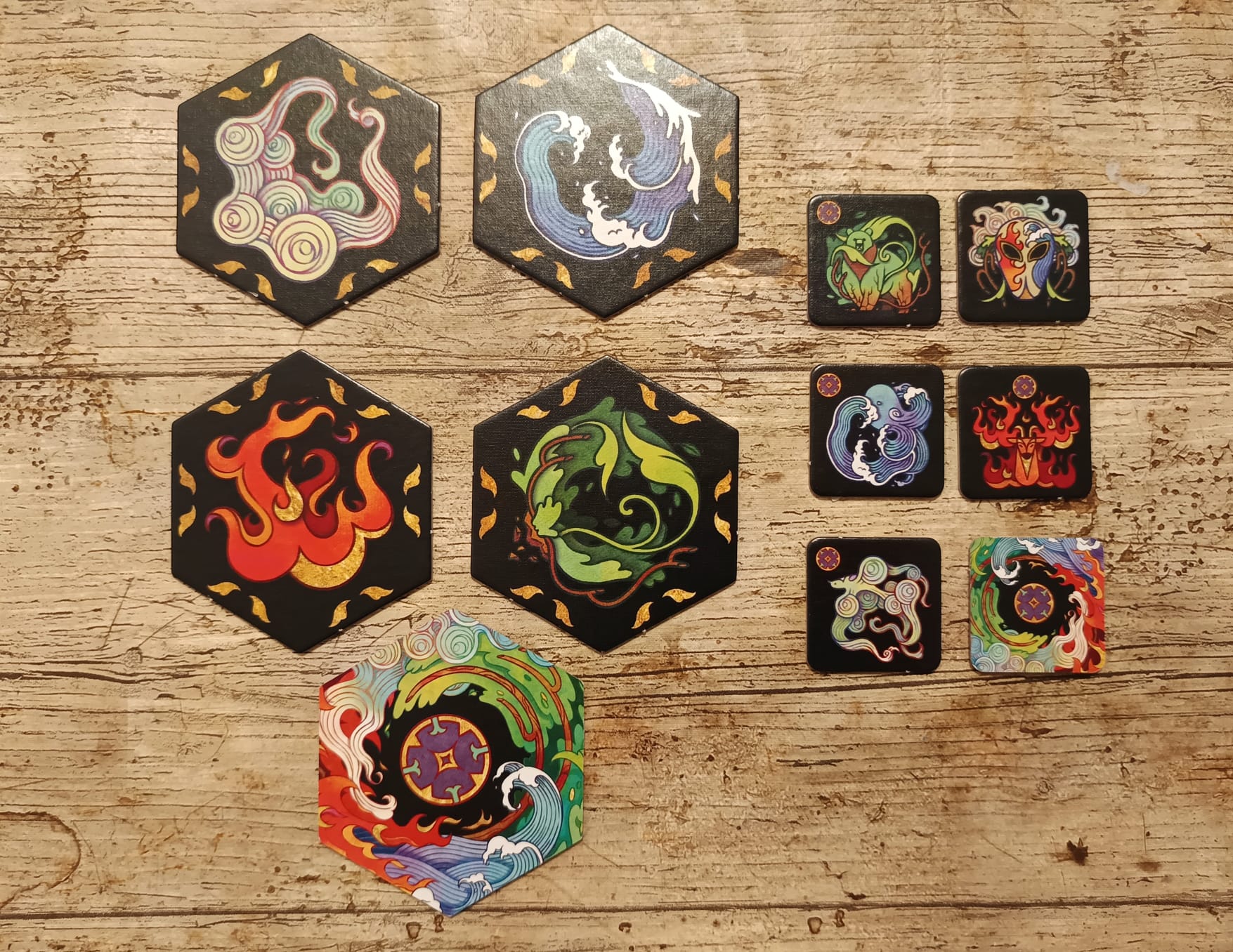 Es gibt im Spiel verschiedene Plättchen. Die kleineren sind für das Memoryraster. Die großen Hexagone sind für den Pfad.