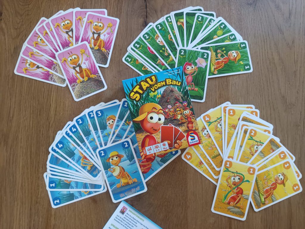 Auf dem Bild ist das Spiel Stau vorm Bau zu sehen und der Inhalt, der in der Schachtel vorhanden ist. Das sind Karten, sowie die Spielanleitung.