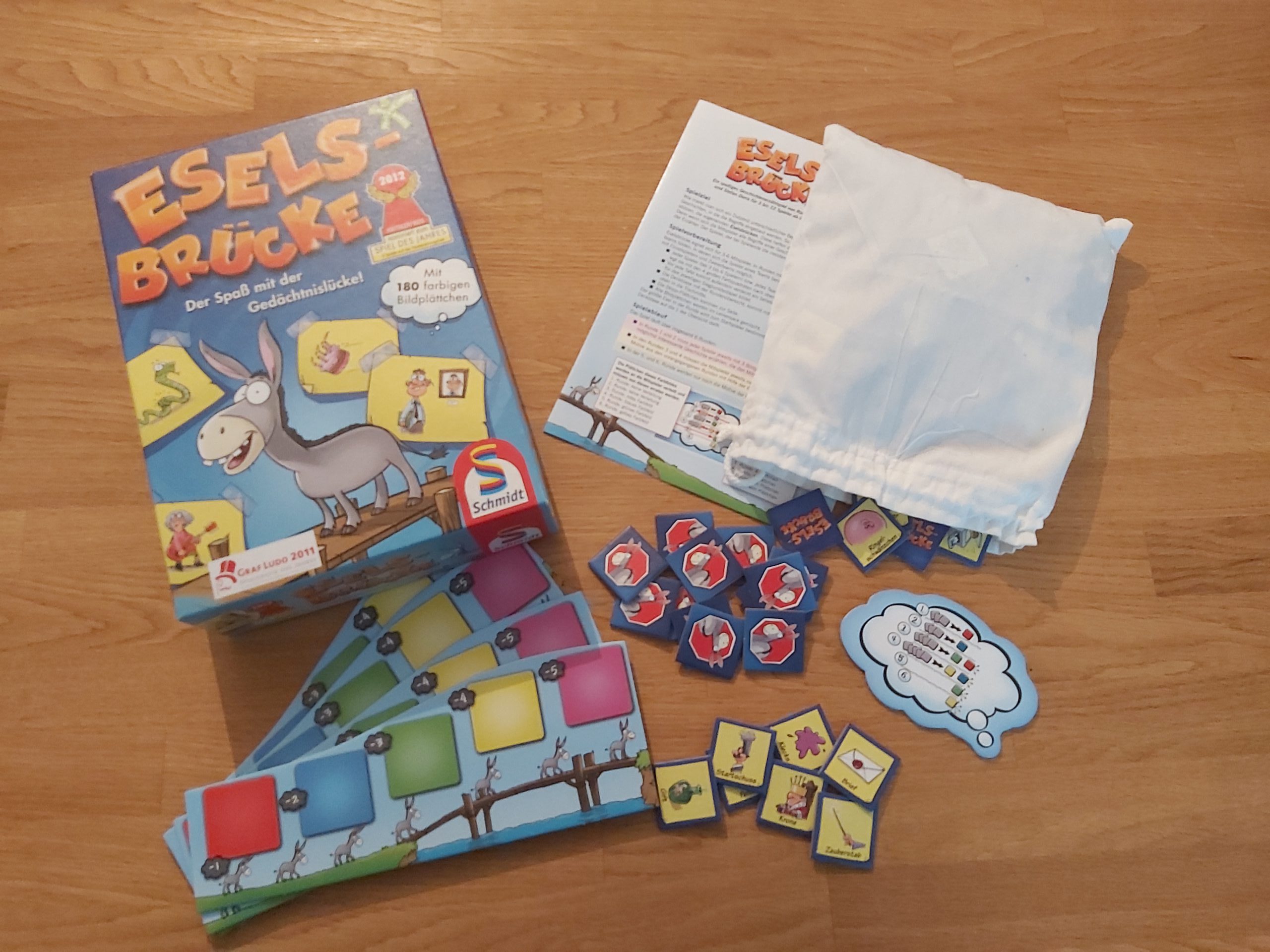Zu sehen ist die Verpackung sowie das Spielmaterial von Eselbrücke.