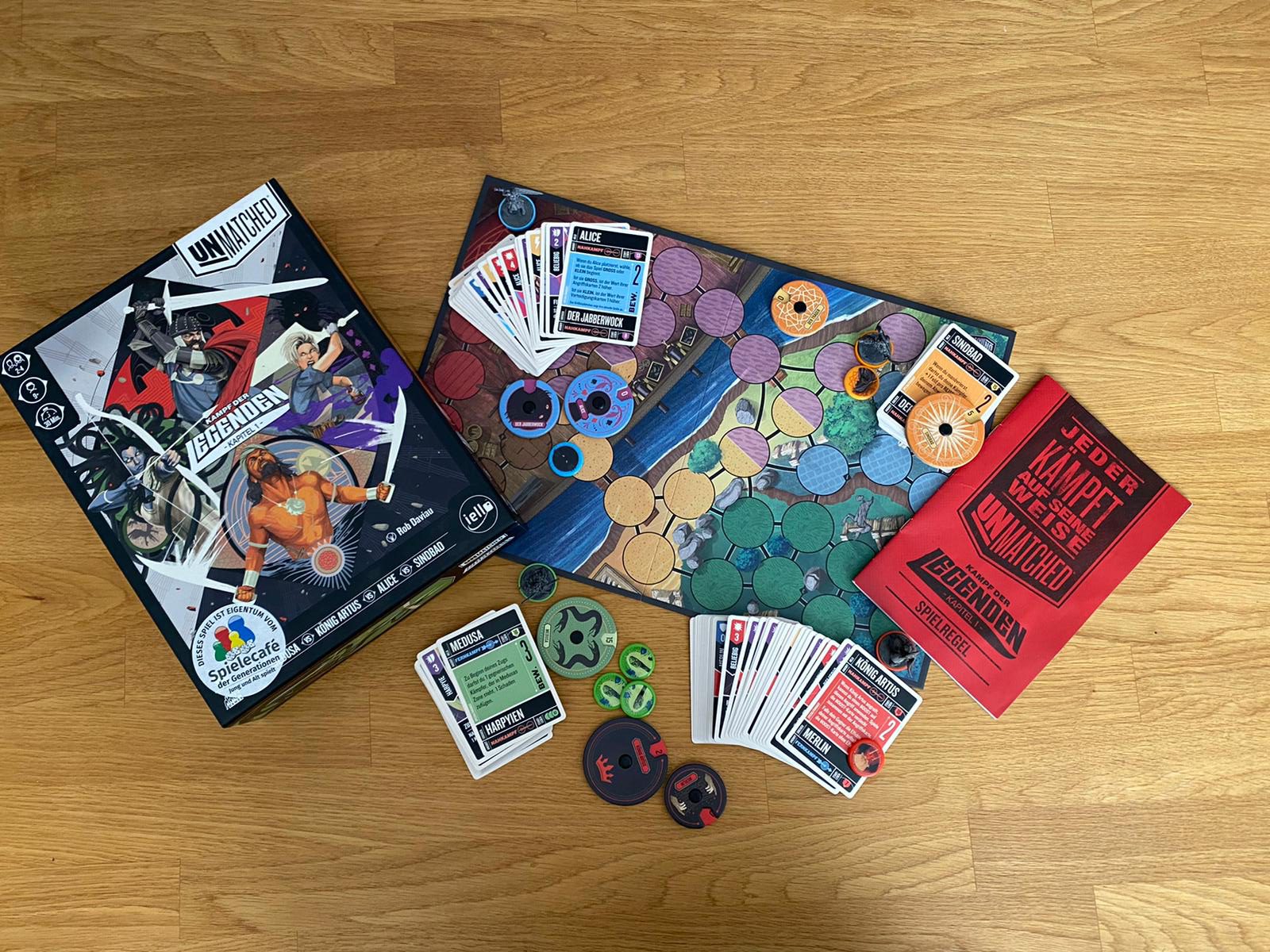 Zu sehen ist das Spiel Unmatched mit gesamtem Spielmaterial.
