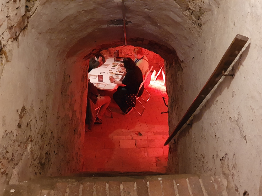 Treppengang zu einem Kellergewölbe, unten: Speielrunde