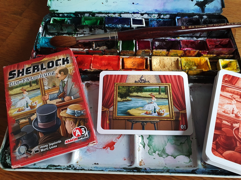 Spielschachtel und Inhalt, zur Dekoration ein Farbkasten und ein Pinsel