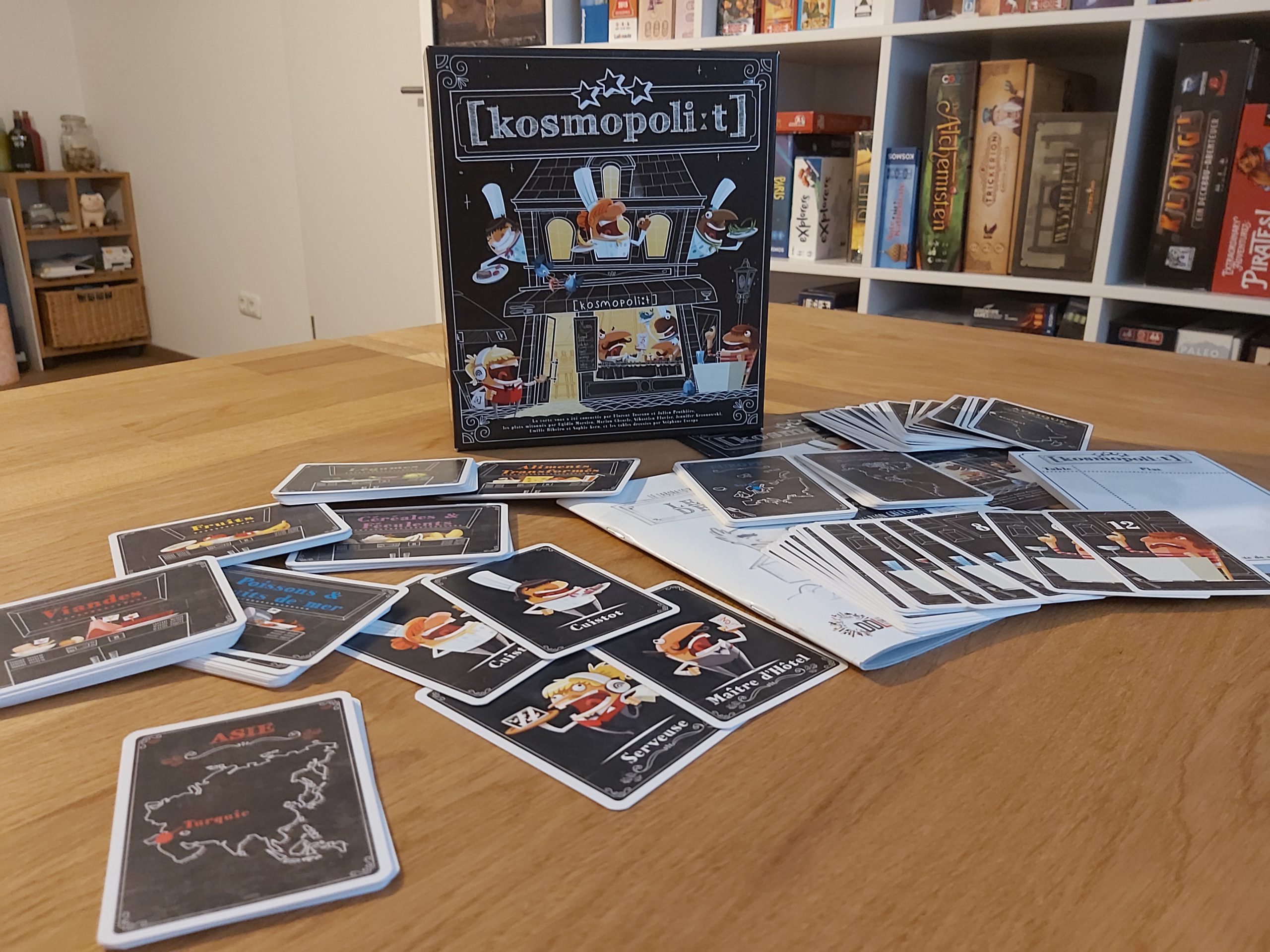 Zu sehen ist das Spiel Kosmopoli:t mit dem gesamten Spielmaterial.