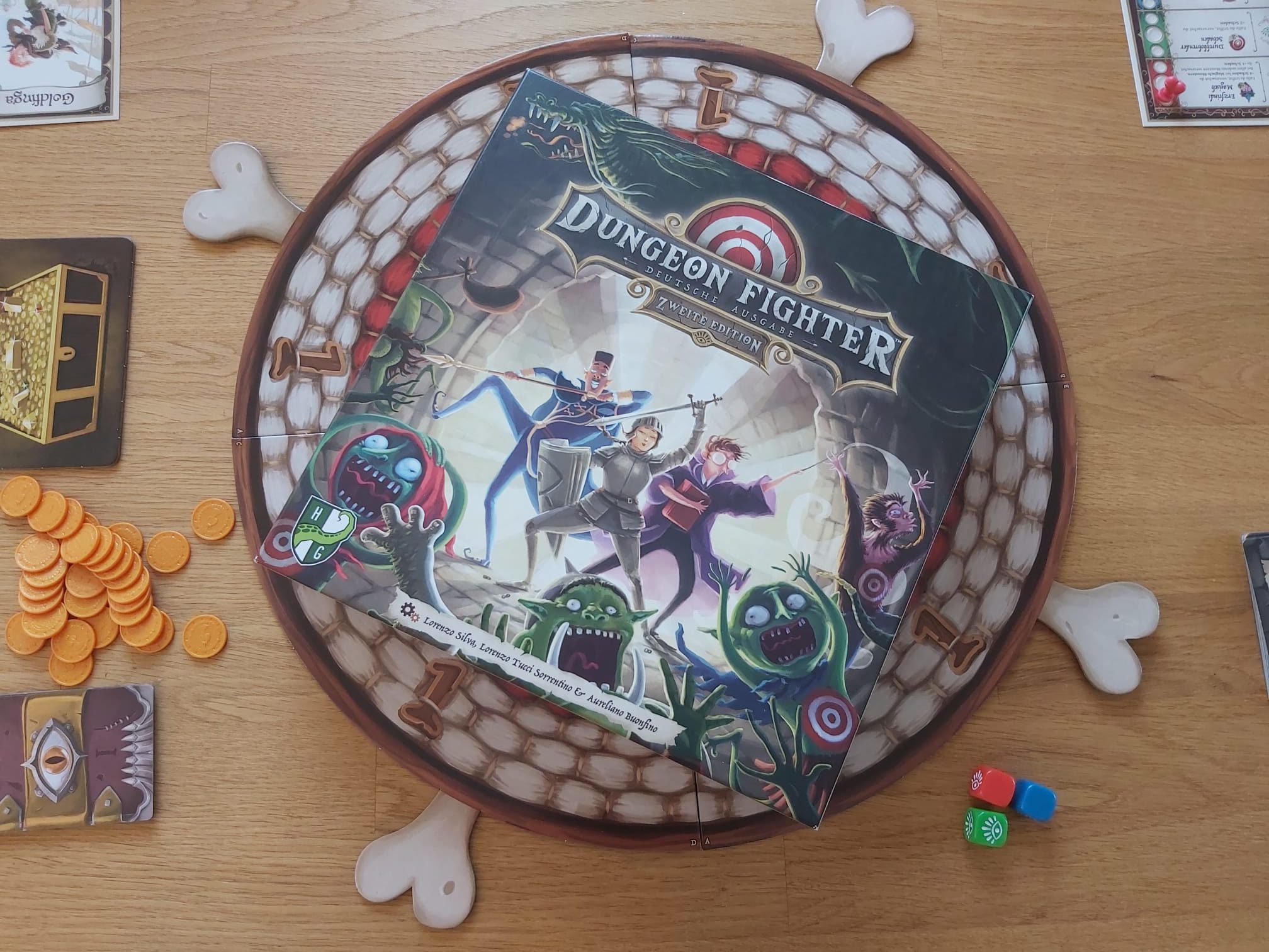 Zu sehen ist das Spiel Dungeon Fighter mit Verpackung und Inhalt.