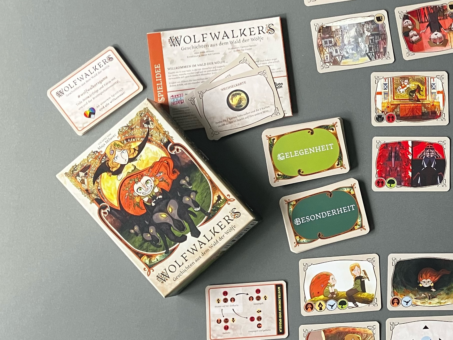 Spielschachtel liegt neben vielen Karten des Spiels