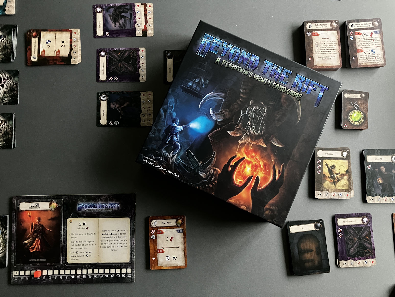 Die Spielschachtel liegt auf dem ausgebreiteten Spiel für 2 - viele Karten werden gespielt werden.