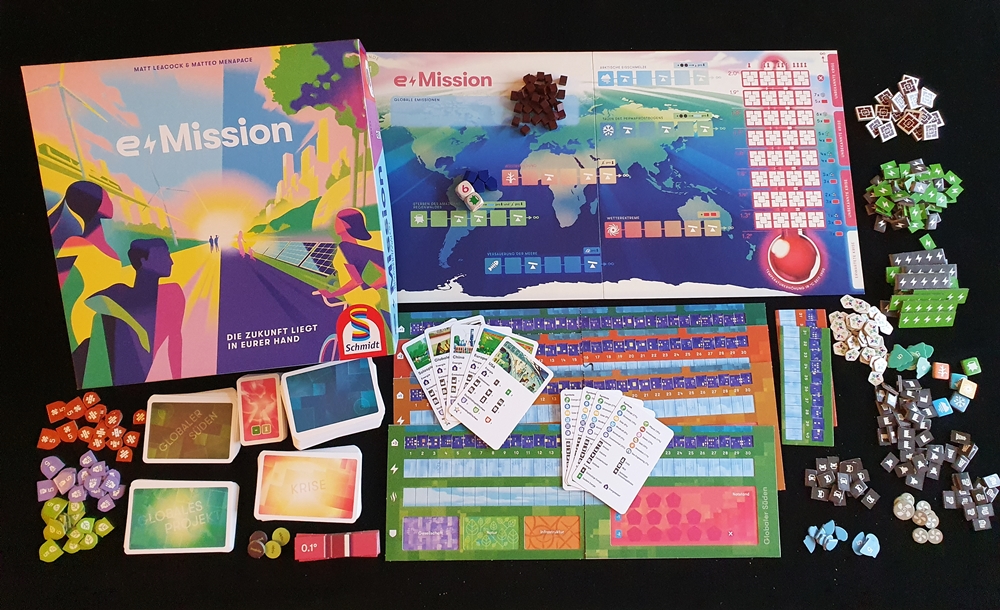 Die Spielschachtel liegt auf dem Tisch, auf dem Übersichtplan und dem Spielmaterial