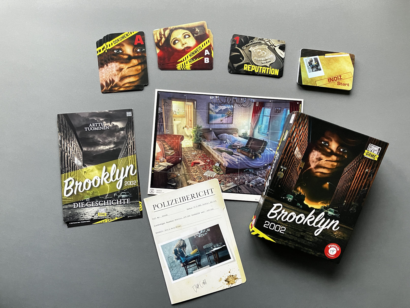 Das gesamte Spielmaterial auf dem Tisch - über Karten, ein Storyheft und eine Übersicht über den Tatort entfaltet sich die Handlung und mit ihr das Spiel.