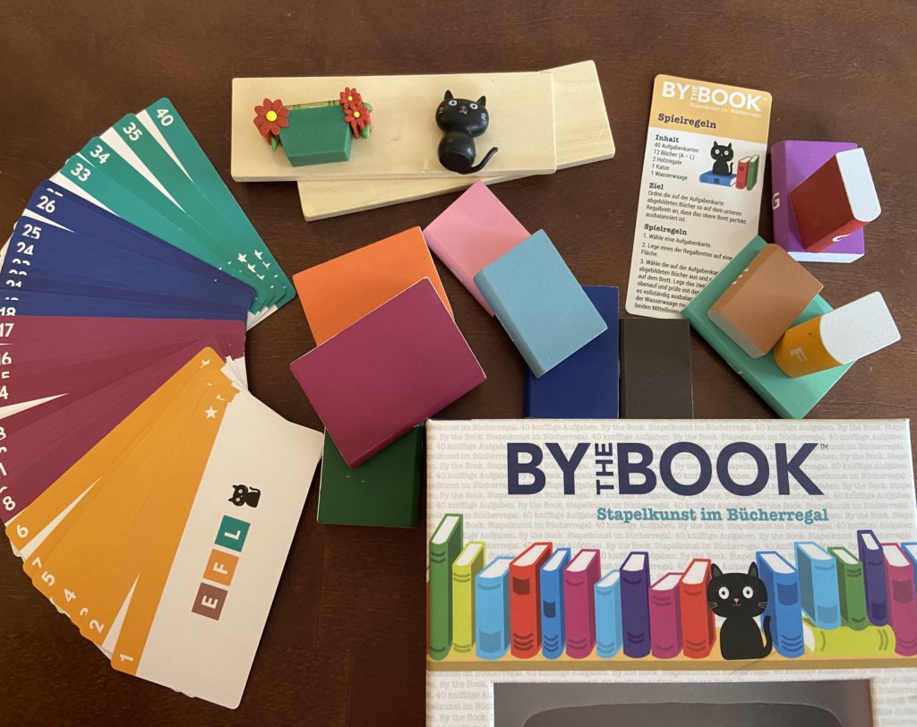 Schachtel und Holzbücher und Karten ausgebreitet.