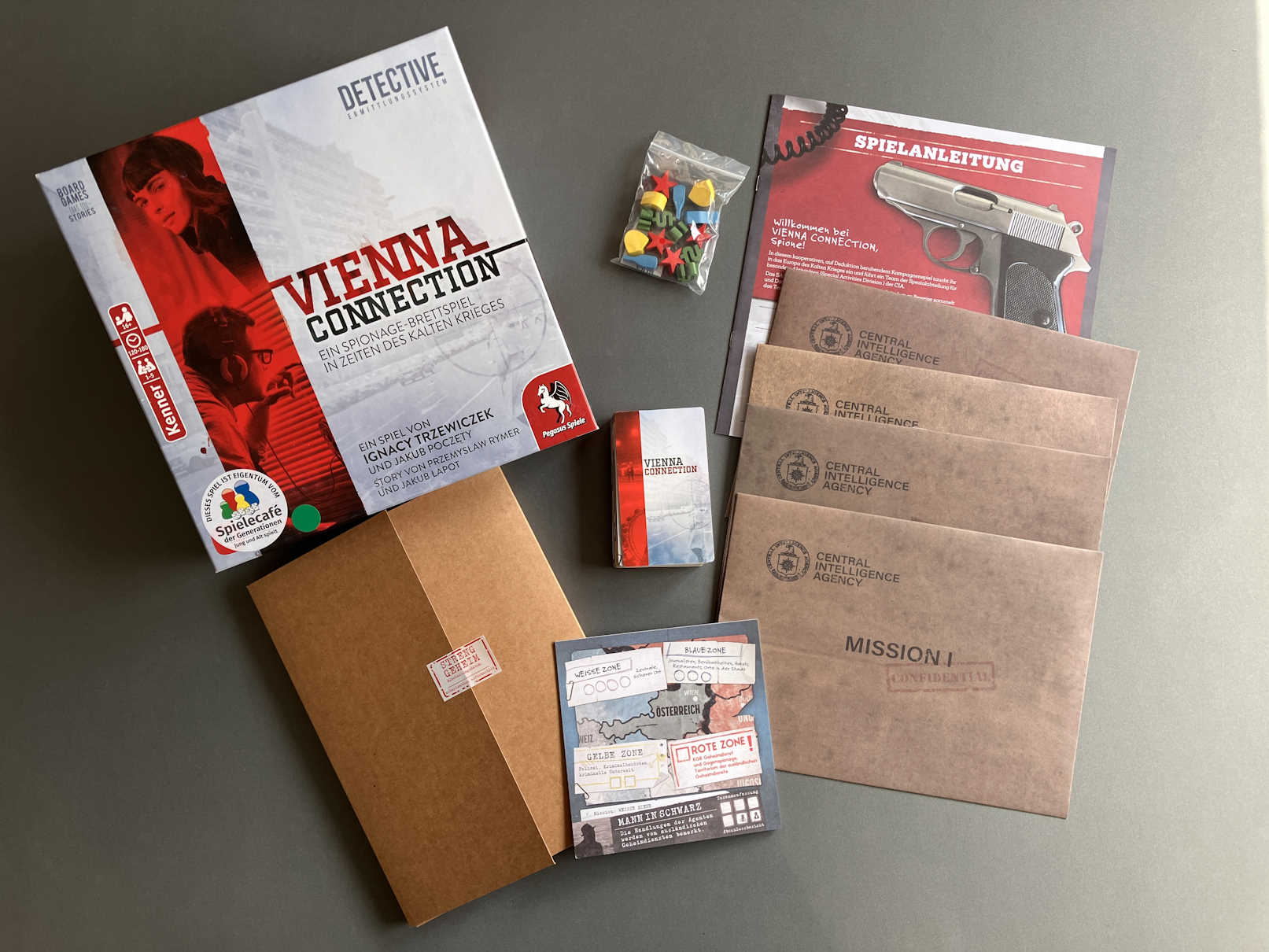 Blick in die Schachtel, das Spielmaterial liegt ausgebreitet auf dem Tisch.