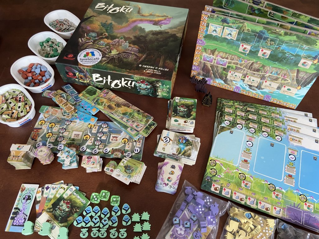 Schachtel und gesamtes Spielmaterial des Spiels: Plättchenstapel, großes Spielbrett, Karten, Ressourcen.