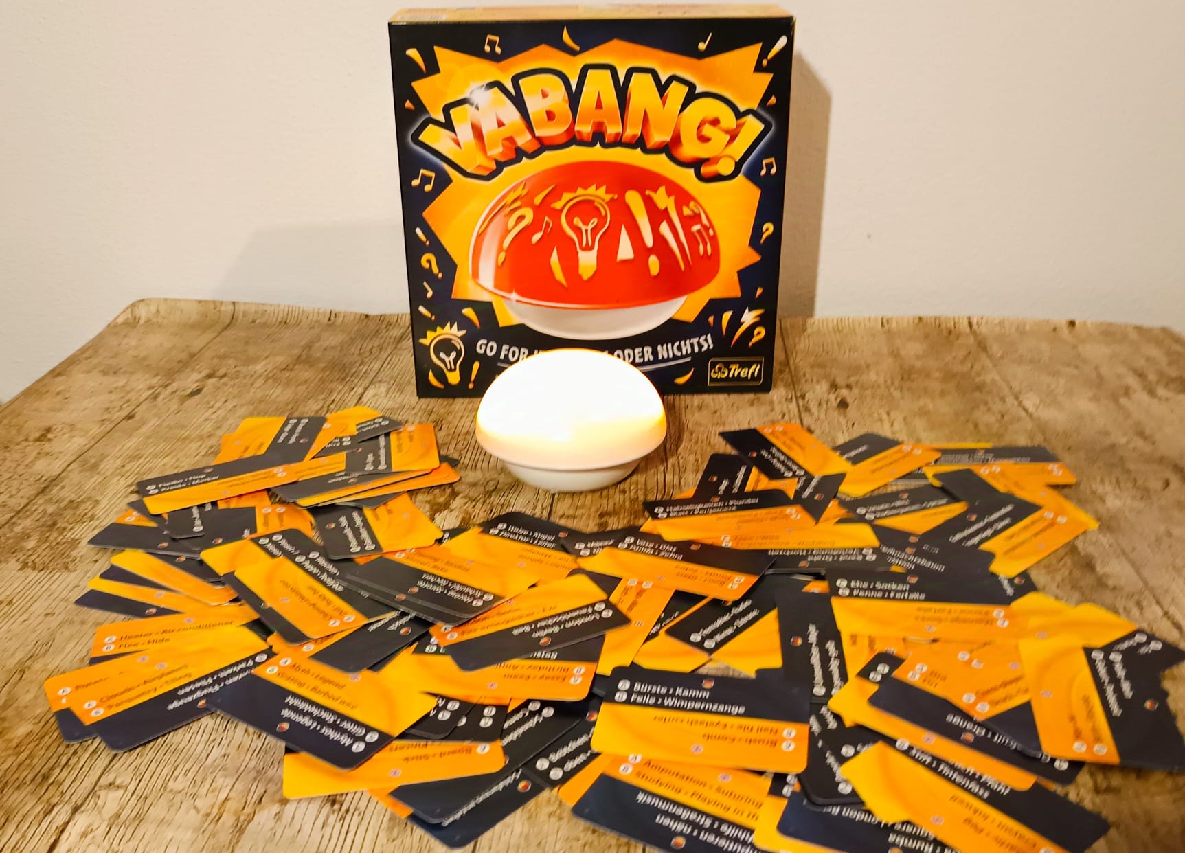 Spieleschachtel mit leuchtendem Buzzer und vielen Wortkarten.