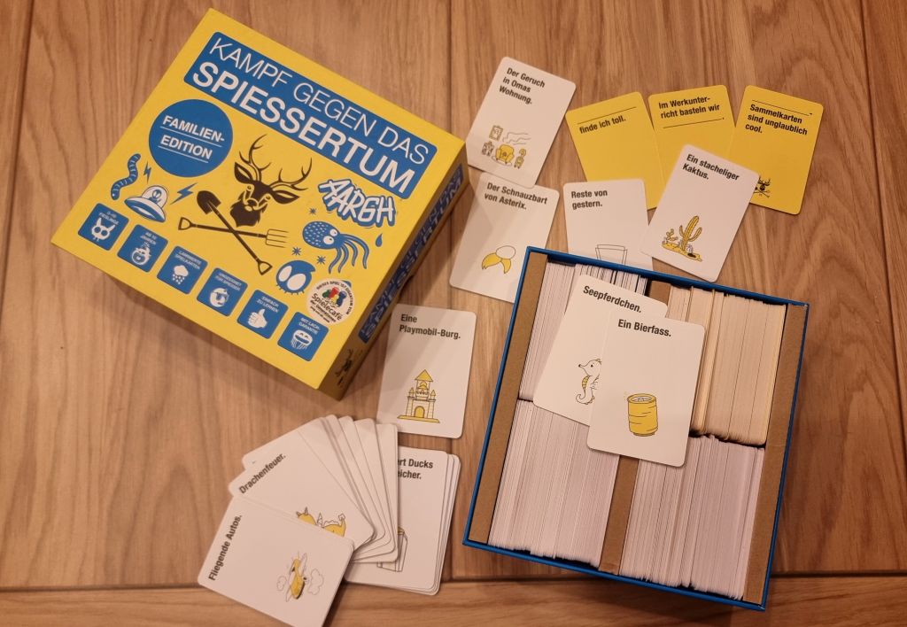 Es ist das gesammte Spielmateriel zu sehen. Einige lose Karten, die meisten jedoch noch im Karton