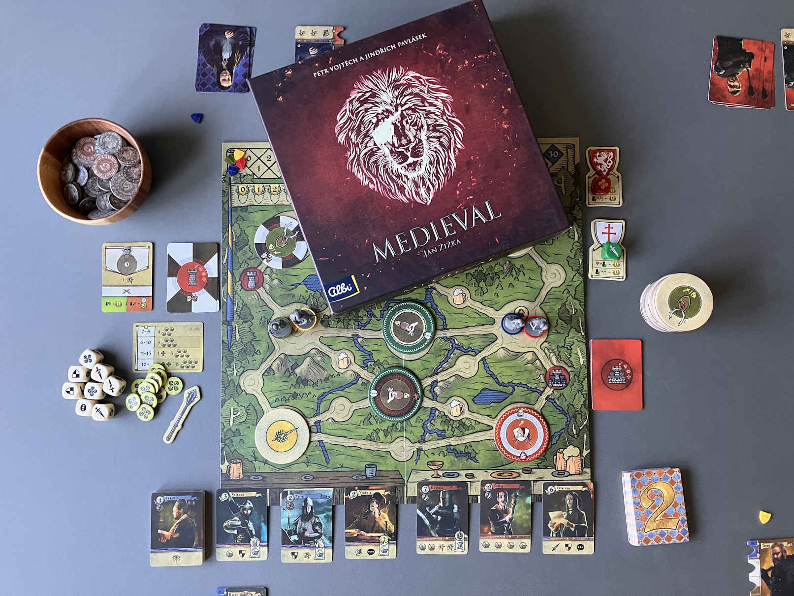 Das Spiel aufgebaut für die Partie zu viert. Die Spielschachtel liegt dekorativ auf dem Plan